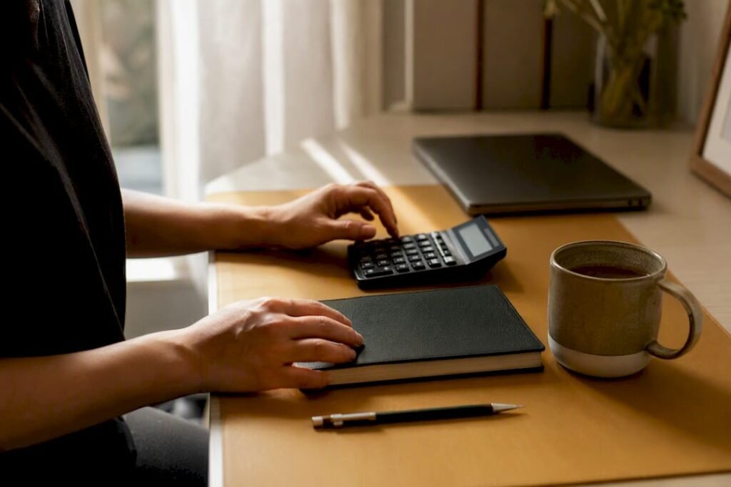 Hands arranging financial tools with coffee on desk